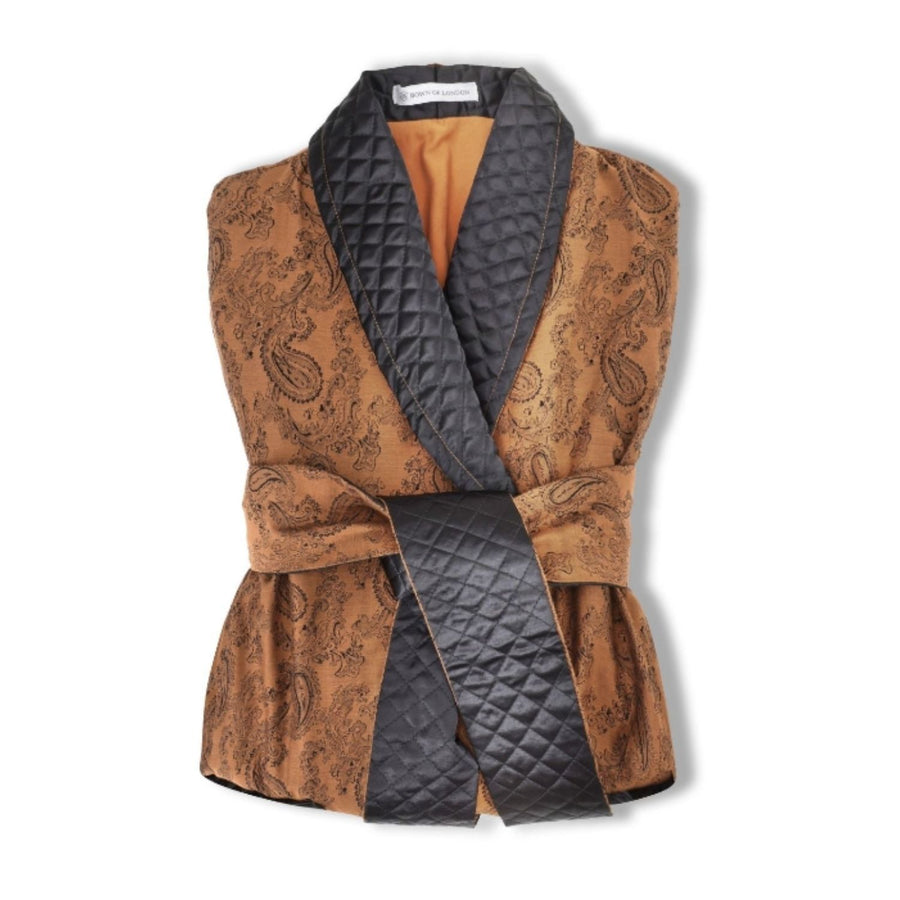 Gold paisley patterned vest with quilted black interior on a white background