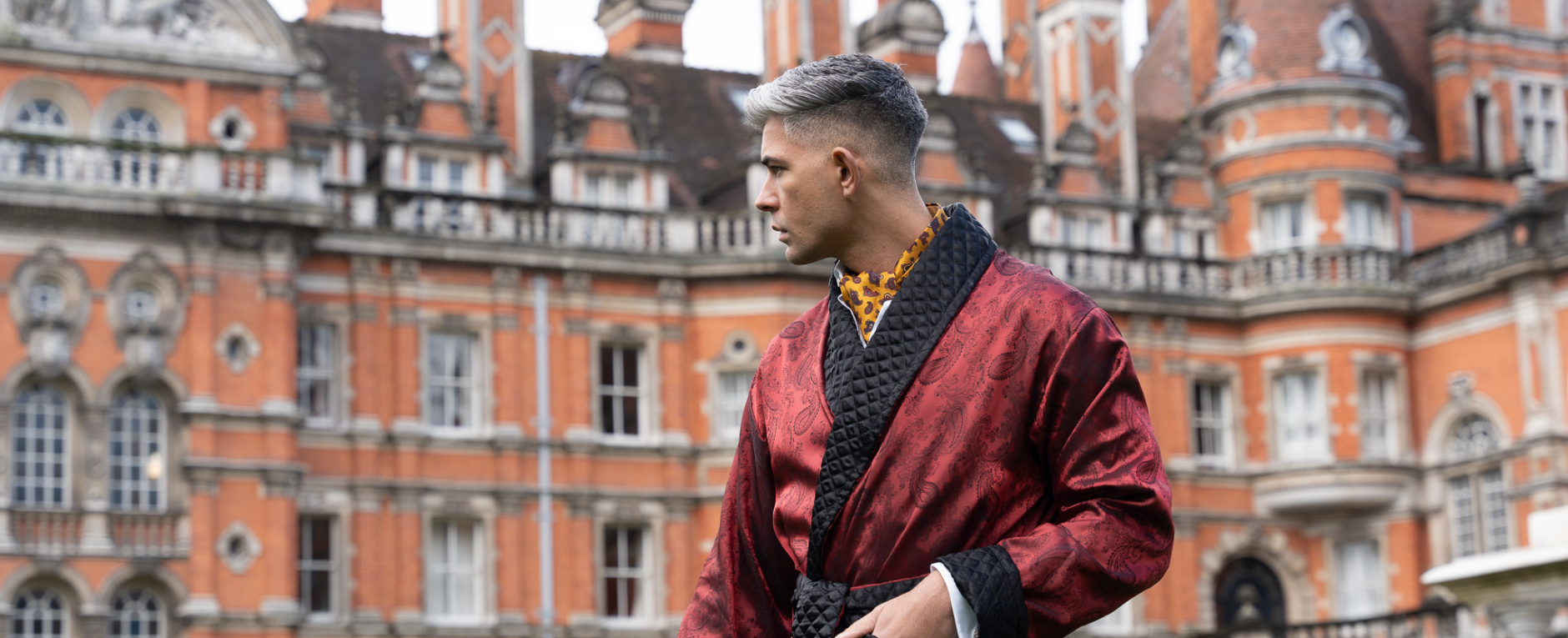 Landscape Photo of Model Wearing Clarke Mens Red Smoking Jacket Infront Of A Grand Old Building | Bown of London